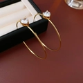 Makro-Detail von vergoldeten C-Ohrringen mit funkelnden Zirkonia in Herzform - Echt vergoldeter silberner Ohrstecker / Gold