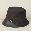 Dettaglio del cappello bucket in cotone con tesa in pelle e placca logo dorata - M (56-58cm) / caffè