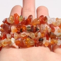 Hand holding polished natural red agate chips beads strands for DIY jewelry making - Red Agate Chips