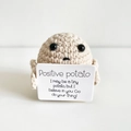 Handmade crochet positive potato doll holding a motivational card on white background - Small Potato Off-White P