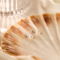 Dettaglio di orecchini a nodo in argento con perle bianche rotonde su una conchiglia - Orecchini d'argento / Orecchini a lobo con perle