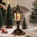 Close-up of lighted Santa Claus snow globe lantern on wood base with festive background - Santa Claus