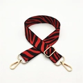 Close-up of zebra pattern woven bag strap with golden metal lobster clasps and buckle - Silver Clasp / Red