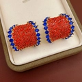 Nahaufnahme von Vintage C-Ohrringen mit roten und blauen Strasssteinen in einer Box - Silbernadel-Gold-Blau-Orange