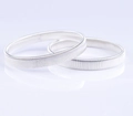 Close-up of dual silver spring metal elastic armbands with a polished reflective finish - Silver