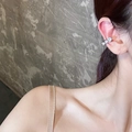 Primer plano de un ear cuff de corazón con circonitas brillantes en oreja sin agujero. - Plata - Oreja Derecha