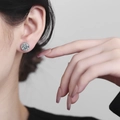 Halo stud earring with a 2-carat round-cut zircon centerpiece on a female model - Copper / White Gold