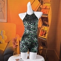 Dettaglio della tuta sexy con scollo all'americana, stampa verde e tessuto lucido - S / Verde
