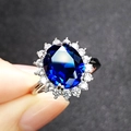 Blauer Saphirring im Blumendesign mit ovalem Hauptstein und Zirkonia-Halo-Effekt - Verstellbarer Ring