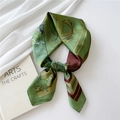 Elegant green silk scarf with horse and harness pattern folded in a circular necktie knot - Patchwork Frame Horse Green