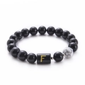Detail of 10mm black onyx and white turquoise beads with a golden letter F charm - Letter F