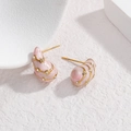 Pink marbled shell earrings with gold trim and crystal accents on white texture - Pink