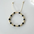Detailed shot of black crystal beaded bracelet with 18k gold beads and adjustable cord - Black