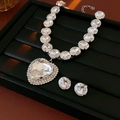 Vista dettagliata del lussuoso set collana a cuore e orecchini a lobo con grandi cristalli - Set da Due Pezzi - Argento