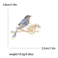 Detailed size view of enamel magpie brooch on pine branch with metric and imperial units - Blue