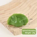 Realistic green spinach dumpling PVC keychain model on light wood surface - Green Spinach Dumpling - No Clip