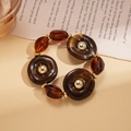 Detail of amber acrylic rings and gold beads on a vintage sweater necklace - Bracelet / Dark Coffee