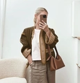 Close-up of olive green quilted jacket featuring khaki contrast trim and button closure - Coffee