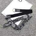 Detalle de cinturón de lona con anillas en D y cinturón de tela con estampado de cachemira - Negro