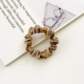 Elegant gold metallic silk scrunchie for hair styling on clean minimalist background - Gold Metallic Texture