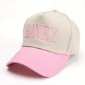 Dettaglio del ricamo rosa 'HONEY' su berretto da baseball in cotone beige e rosa - Rosa