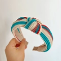 Close-up of a knotted striped headband featuring silk-like beige, blue, and red patterns - Knot Headband / Beige