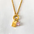 Gold-plated stainless steel necklace featuring an 'F' letter tag and a pink zircon pendant. - F