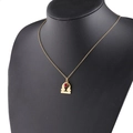 Detailed close-up of gold Libra zodiac necklace with a red gemstone on a black bust model - 7-7 Libra