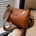 Brown cylinder crossbody bag with textured lychee grain leather and wide ethnic strap - Brown