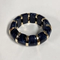 Détail de blocs de résine marbrée bleu foncé et d'entretoises dorées sur un bracelet - Tourbillon bleu blanc