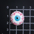 Detailed view of 2cm Halloween eyeball resin flatback with red veins on a scale mat - 2cm Diameter / Small Blue
