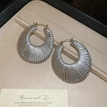 Detalle de pendientes de aro geométricos tejidos en plata en un estuche de joyería negro - Pequeño / Plateado