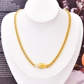 Gold chunky Cuban chain necklace with emerald-eyed snake head clasp on a jewelry mannequin - Necklace