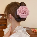 Dettaglio di un fermaglio per capelli con rosa in tessuto rosa indossato da una modella - Rosa