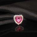 Close-up of pink heart-shaped crystal with white claw-set rhinestones on black silk - Rose Red