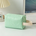 Dettaglio della borsa da trucco in ecopelle verde menta con strisce trapuntate e manico intrecciato - verde chiaro