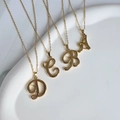 Dettaglio di ciondoli monogramma in acciaio dorato 18K con lettere A B C D su vassoio bianco - Set di collane / Lettera A + Catena