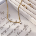 Detail view of gold necklace with teardrop pendant and matching rings in a gift box - Water Drop Zirconia