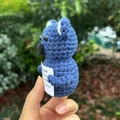Blaue handgefertigte Häkel-Koala-Puppe mit Motivationsschild in natürlicher Umgebung - Blauer Koala
