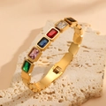 Detail of gold-plated bangle featuring colorful rectangular gemstones on rock display - Square Multicolor Zirconia Style (R809) / Gold