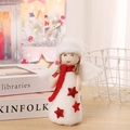 Detail of Christmas angel doll with red knit scarf and glitter star on wooden desk - White Hat Angel with Red Scarf