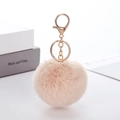 Close-up of a soft pink faux rabbit fur pom pom keychain with gold metal lobster clasp - Khaki