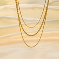 Macro view of layered 18K gold-plated stainless steel rope and snake chains on silk - Triple Chain (H656) / 40+5/45+5/50+5cm / Gold