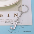 Silver metal letter J keychain on light blue background with size measurement markers - Letter-J