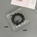 Detailed view of 13x13cm thick transparent PVC ziplock bag showing jewelry storage capacity - 30 Silk 13x13cm
