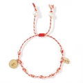 Close-up of woven red and gold cotton bracelet with pearl accents and religious medals - Red & White