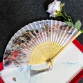 Detail of bamboo folding fan featuring Jiangnan water town art and elegant tassel - Jiangnan Water Town - Light Handle