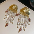 Detailed shot of vintage beaded tassel earrings with gold accents and opal stones - Gold