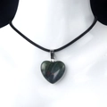 Dark green heart-shaped agate pendant with red spots on a black woven necklace cord - African Blood Stone