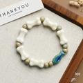 Ceramic beaded bracelet with white bone beads and a blue gradient fish charm - Blue Ceramic Fish Style (1645-10) / Blue-green